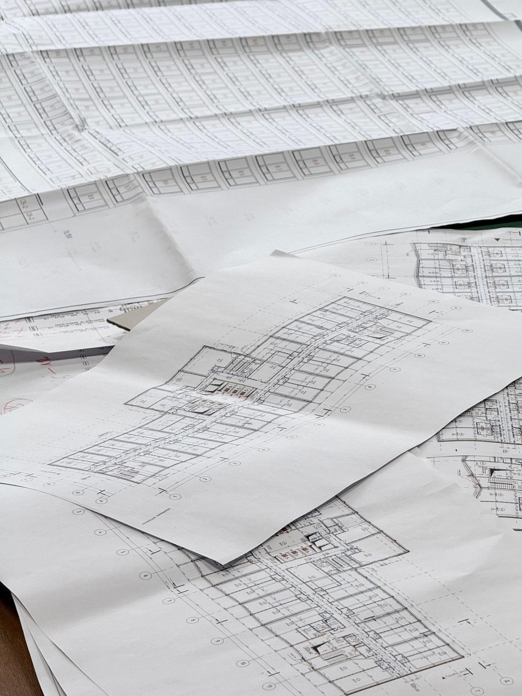 Detailed architectural blueprints spread across a desk